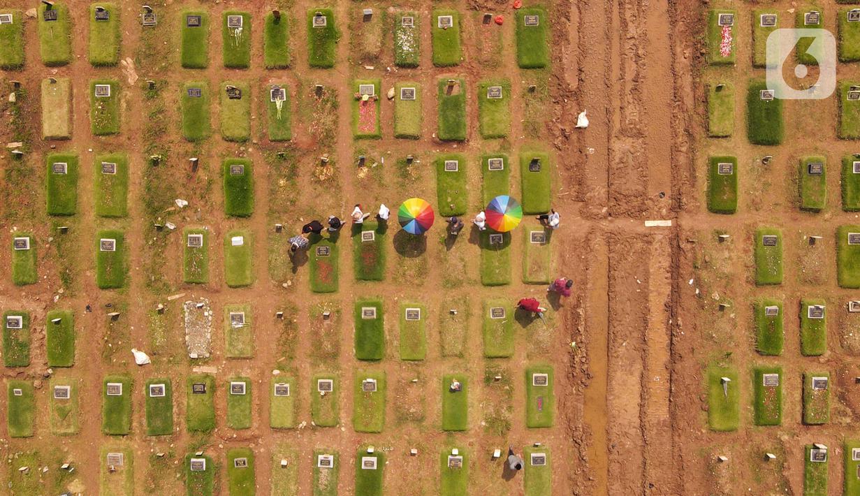 <p>Foto udara memperlihatkan warga melakukan ziarah di area pemakaman khusus COVID-19 di TPU Rorotan, Cilincing, Jakarta Utara, Rabu (4/5/2022). Sejumlah tempat pemakaman umum masih dipadati oleh keluarga yang melakukan ziarah di H+3 Lebaran. (merdeka.com/Imam Buhori)</p>