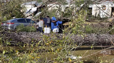 Teman dan keluarga berdoa di luar rumah mobil yang rusak di Flatwood, Alabama, Rabu (30/11/2022). Badai Tornado melanda daerah tersebut yang mengakibatkan dua orang tewas di komunitas Flatwood di utara kota Montgomer. (AP Photo/Butch Dill)