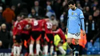 Gelandang Manchester City asal Portugal #20, Bernardo Silva, bereaksi saat gelandang Manchester United asal Pantai Gading #16, Amad Diallo, merayakan gol kedua tim selama pertandingan Liga Primer Inggris antara Manchester City dan Manchester United di Stadion Etihad di Manchester, Inggris barat laut, pada tanggal 15 Desember 2024. (Paul ELLIS/AFP)