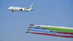 Sebuah Etihad Boeing 787 Dreamliner terbang bersama tim terbang aksi militer Emirati Forsan di Dubai Air Show di Dubai, Uni Emirat Arab (14/11/2021). Dubai Air Show dua tahunan dibuka Minggu ketika penerbangan komersial mencoba untuk melepaskan diri dari pandemi virus corona. (AP Photo/Jon Gambrell)