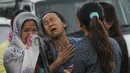 Seorang kerabat menangis ketika jenazah korban jatuhnya helikopter tiba di sebuah rumah sakit di Ibu Kota Nepal, Kathmandu, Senin (8/8). Sebuah helikopter dilaporkan menabrak bukit dan menewaskan tujuh penumpang, termasuk bayi. (AFP PHOTO/BIKASH Karki)