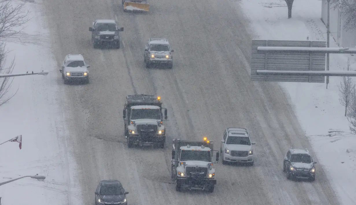 Kendaraan bajak salju melintas dari West Michigan Avenue di pusat kota Kalamazoo, Michigan, Rabu (2/2/2022). Gubernur mendesak penduduk untuk menjauh dari jalan dan menutup sekolah dan kampus. (Joel Bissell/Kalamazoo Gazette via AP)