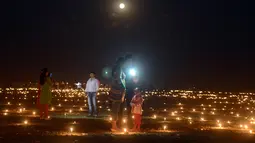 Warga India mengabadikan gambar di Sangam saat festival 'Dev Deepawali,' atau festival cahaya, di Allahabad, Rabu (25/11).  Festival ini adalah perayaan atas kemenangan kebaikan atas kejahatan. (AFP PHOTO/Sanjay Kanojia)