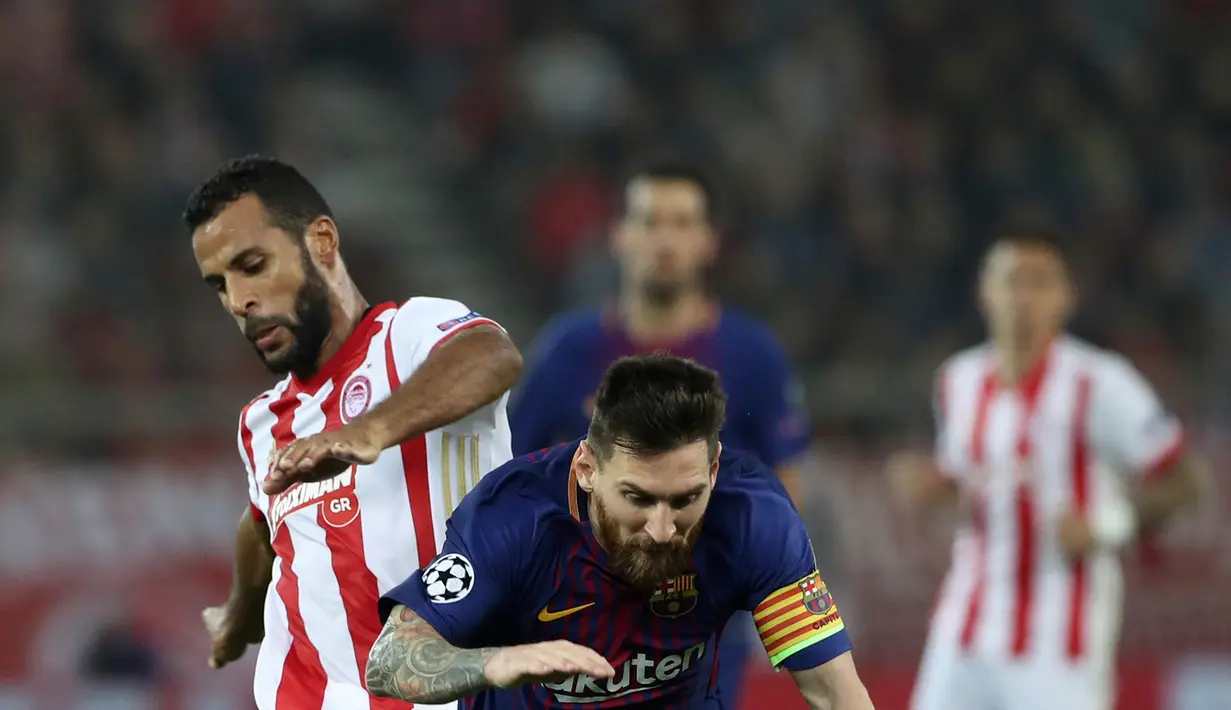 Pemain Olympiakos, Alaixys Romao merebut bola dari pemain Barcelona, Lionel Messi pada laga babak penyisihan Grup D Liga Champions di Georgios Karaiskáki, Rabu (1/11). Barcelona hanya mampu bermain imbang dengan skor 0-0. (AP/Thanassis Stavrakis)