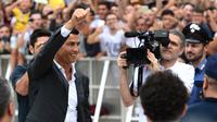Cristiano Ronaldo menyapa suporter Juventus saat tiba di pusat layanan kesehatan Juventus (J-Medical), Turin, Italia, (16/7). Ronaldo akan mengenakan nomor punggung 7, seperti yang dikenakannya di Real Madrid. (AFP Photo/Miguel Medina)