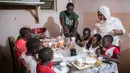 Bara Tambedou (tengah) dan istrinya Mame Sey berbuka puasa bersama keluarga mereka pada hari pertama bulan suci Ramadan, di Dakar, Senegal, Sabtu, (25/4/2020). (AP Photo/Sylvain Cherkaoui)