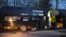 Kendaraan polisi terparkir di depan bus tim Borussia Dortmund yang rusak terkena ledakan di Dortmund, Jerman Barat, Selasa (11/4). Bus membawa pemain Borussia Dortmund untuk pertandingan perempat final Liga Champions melawan Monaco. (Patrik STOLLARZ/AFP)