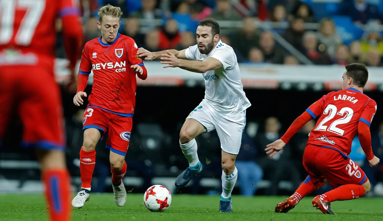 Real Madrid, Jose Luis Fernandez berebut bola dengan pemain Numancia, Daniel Nieto pada leg kedua babak 16 besar Copa del Rey di Santiago Bernabeu, Kamis (11/1). Real Madrid harus menerima hasil imbang 2-2 dengan Numancia. (AP/Francisco Seco)
