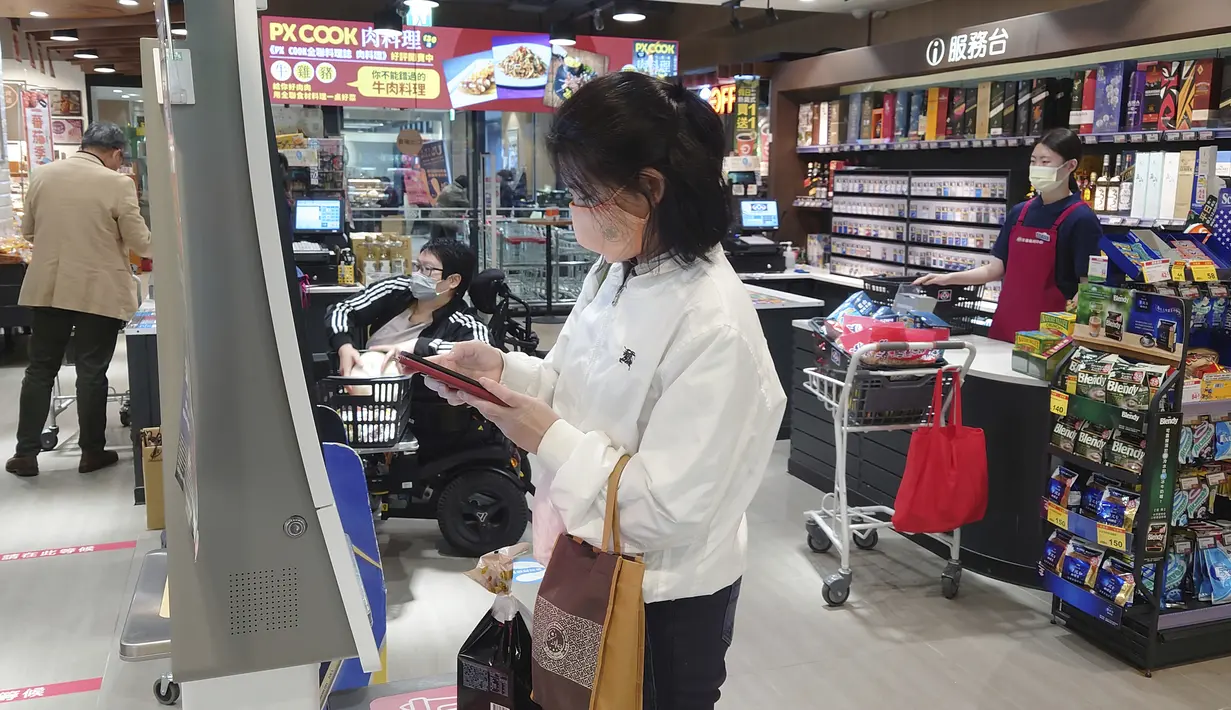 Pengunjung mengenakan masker saat berbelanja di supermarket di Taipei, Taiwan, Senin (20/2/2023). Orang-orang masih diharuskan memakai masker di tempat-tempat seperti rumah sakit dan fasilitas medis serta di angkutan umum. Namun, restoran dan kantor lagi mewajibkan masker. (AP Photo/Chiang Ying-ying)