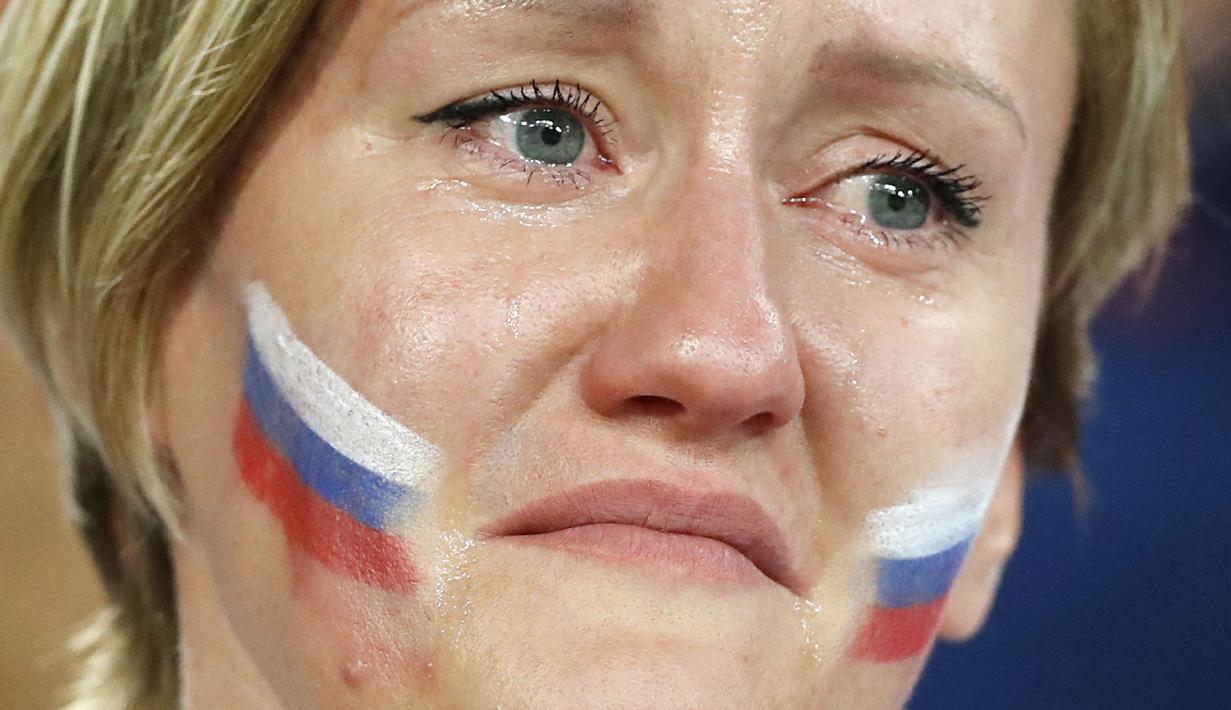 Seorang suporter menangis usai Rusia kalah dari Kroasia pada laga perempat final Piala Dunia di Stadion Olimpiade Fisht, Sabtu (7/7/2018). Rusia kalah adu penalti dengan skor 3-4 dari Kroasia. (AP/Darko Bandic)