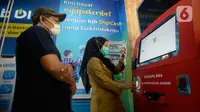 Petugas membantu warga yang akan melakukan pencetakan di mesin Anjungan Dukcapil Mandiri (ADM) di Pamulang Square, Tangerang Selatan, Senin (15/9/2020). Pemkot Tangsel memudahkan pelayanan kependudukan untuk membuat KTP El, Kartu Identitas Anak dan Kartu Keluarga. (merdeka.com/Dwi Narwoko)