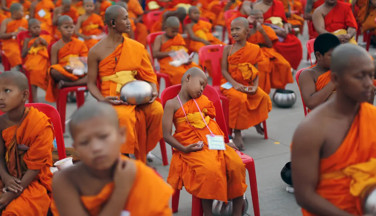 Seorang Biksu Buddha tertidur di kursi saat menunggu acara penerimaan sedekah di kuil Wat Phra Dhammakaya, Bangkok, Thailand, (22/4). Kegiatan ini juga sebagai penasbihan para bhikkhu dan samanera atau calon Biksu. (REUTERS / Jorge Silva)