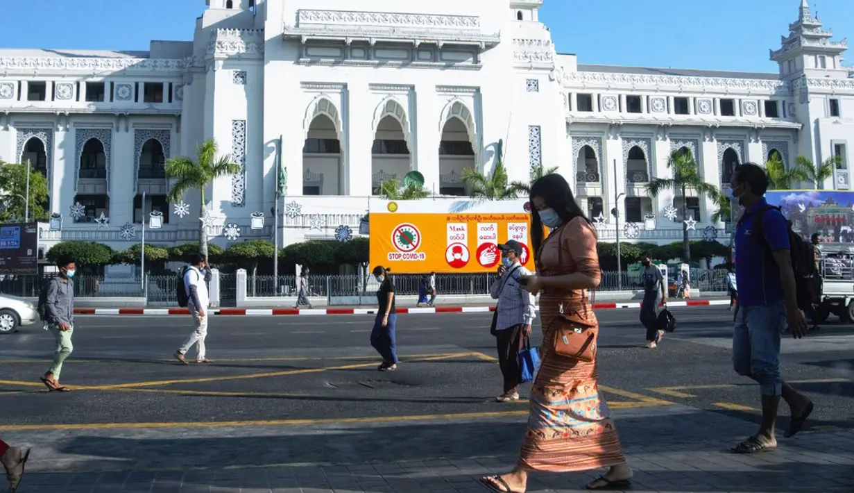 Orang-orang berjalan melewati Balai Kota sehari setelah militer Myanmar merebut kekuasaan, Yangon, Myanmar, Selasa (2/2/2021). Militer Myanmar menahan pemimpin yang terpilih secara demokratis Aung San Suu Kyi dan memberlakukan keadaan darurat satu tahun. (STR/AFP)