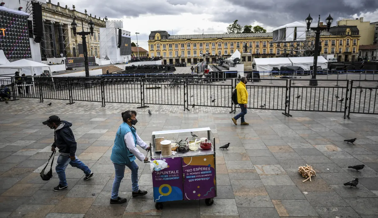 Seorang pedagang berjalan di Bolivar Square di mana panggung untuk upacara pelantikan Presiden terpilih Kolombia Gustavo Petro sedang didirikan, di Bogota pada 5 Agustus 2022. Gustavo Petro akan menggantikan Iván Duque Márquez sebagai presiden Kolombia. (Juan BARRETO / AFP)