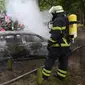 Petugas pemadam kebakaran memadamkan api sebuah mobil yang hangus terbakar usai aksi demo menentang KTT G20 di Hamburg, Jerman utara, (7/7). (Bodo Marks / dpa via AP)