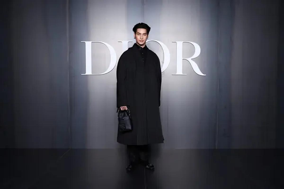 Apo, bintang asal Thailand ini tampil keren dengan long coat hitam yang dipadukan dengan loose pants serta mini handbag berwarna senada. Gaya monokromatiknya memberikan kesan modern dan berkelas. [Dok/DIOR].