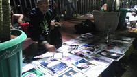 Seorang pedagang, Azizin, menjajakan foto pimpinan Front Pembela Islam jelang demo 2 Desember. (Liputan6.com/Muslim AR)