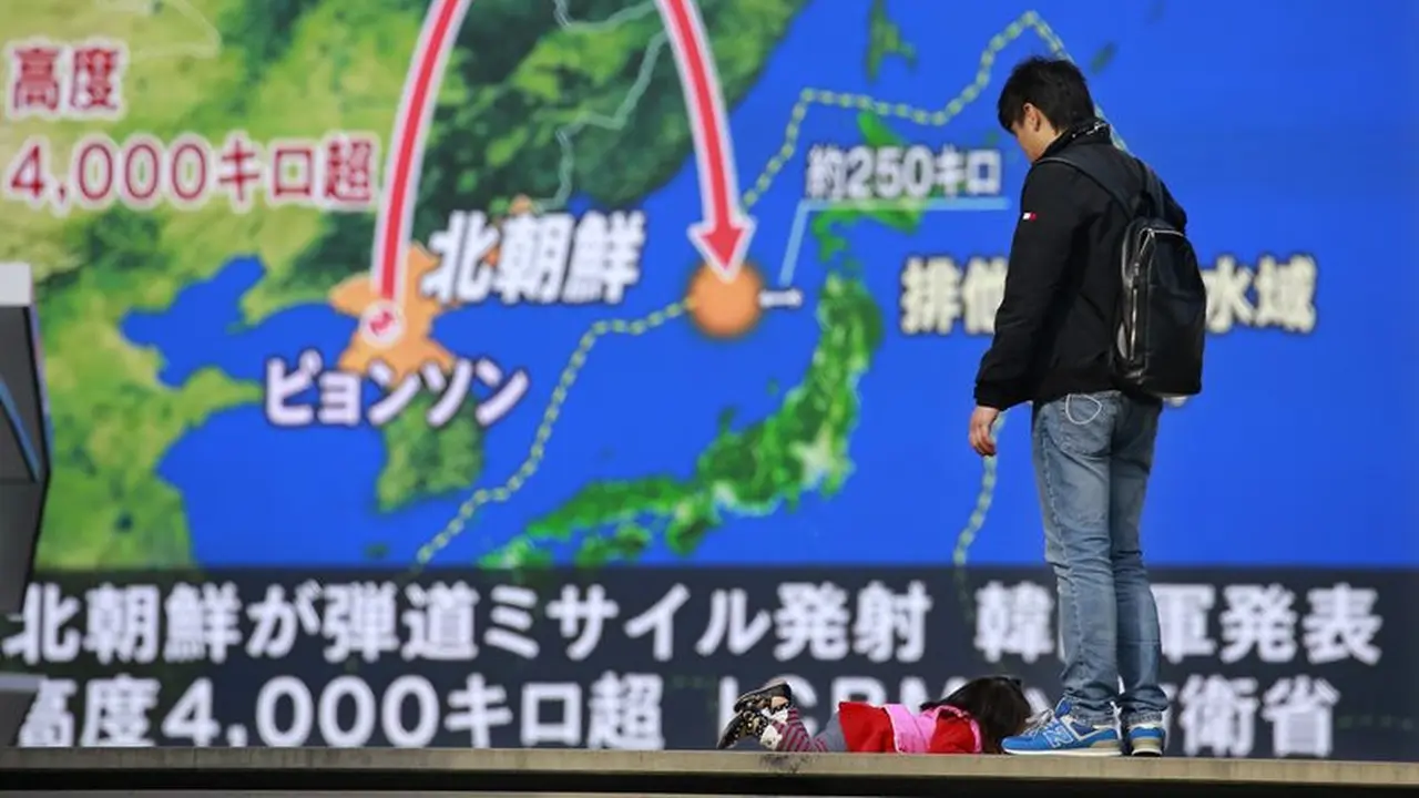 Tayangan berita di Tokyo yang menampilkan visualisasi rudal Korea Utara yang meluncur pada 29 November 2017. Rudal itu jatuh di Laut Jepang, atau 1.000 km dari titik peluncuran awal, setelah terbang ke angkasa setinggi 4.500 km (AP/Shizuo Kombayashi)