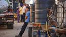Warga Palestina berkumpul di samping gerobak yang ditarik keledai yang dimuat dengan tangki air untuk dijual. (MAHMUD HAMS/AFP)
