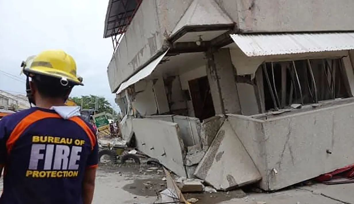 Tim penyelamat memeriksa  bangunan yang runtuh setelah gempa melanda Padada, provinsi Davao del Sur, Filipina selatan (15/12/2019). Gempa tmenyebabkan bangunan tiga lantai runtuh dan membuat warga panik bergegas keluar dari pusat perbelanjaan, rumah dan bangunan lain. (AP Photo)