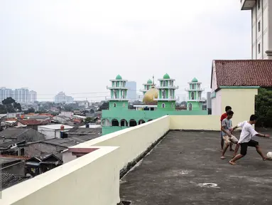 Sejumlah remaja bermain futsal di atas gedung di Pasar Mampang, Jakarta, Rabu (12/7).  Karena kurangnya lahan tempat bermain futsal di jakarta sehingga atas gedung menjadi tempat bermain tanpa menghiraukan keselamatan. (Liputan6.com/Faizal Fanani)