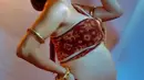 Perempuan 35 tahun itu mengenakan busana adat Bali modifikasi yang memperlihatkan baby bump-nya.