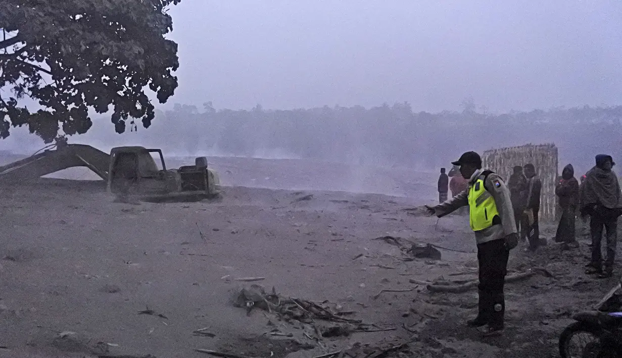 Petugas polisi memeriksa lokasi penambangan pasir yang terkena dampak letusan Gunung Semeru di Lumajang, Jawa Timur, Indonesia, Selasa (1/12/2020). Pihak berwenang sedang memantau beberapa gunung berapi setelah sensor mendeteksi peningkatan aktivitas dalam beberapa minggu terakhir. (AP Photo)