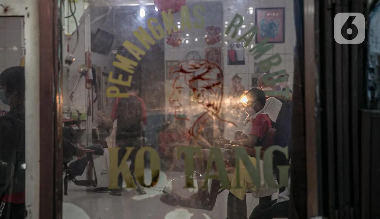 Tempat pangkas rambut di Gang Gloria, Pancoran, Glodok, Jakarta, Rabu (2/2/2021). Gang yang dipenuhi penjual kuliner khas pecinan yang sudah ada sejak tahun 1920-an ini semakin sepi pembeli karena adanya pandemi Covid-19. (Liputan6.com/Faizal Fanani)