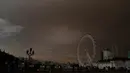 Penampakan langit di atas London Eye yang berwarna kuning kusam menyelimuti kota London, Inggris, Senin (16/10). Fenomena langit yang menjadi mencekam ini disebabkan oleh badai Ophelia yang membawa debu dari Gurun Sahara. (AP Photo/Frank Augstein)