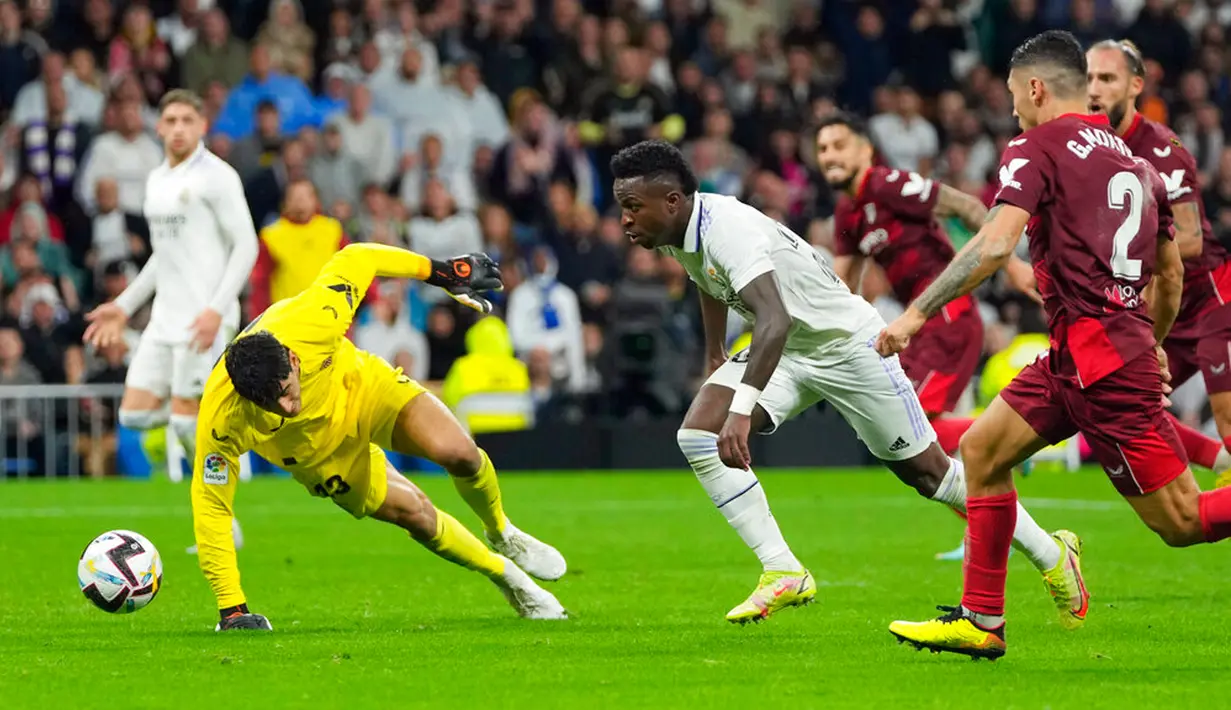 Pemain Real Madrid Vinicius Junior (tengah) berebut bola dengan kiper Sevilla Bono dan Gonzalo Montiel (kanan) pada pertandingan sepak bola Liga Spanyol di Stadion Santiago Bernabeu, Madrid, Spanyol, 22 Oktober 2022. Real Madrid menang 3-1 atas Sevilla. (AP Photo/Manu Fernandez)