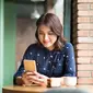 Seorang wanita cantik menggunakan smartphone. (Shutterstock/Makistock)