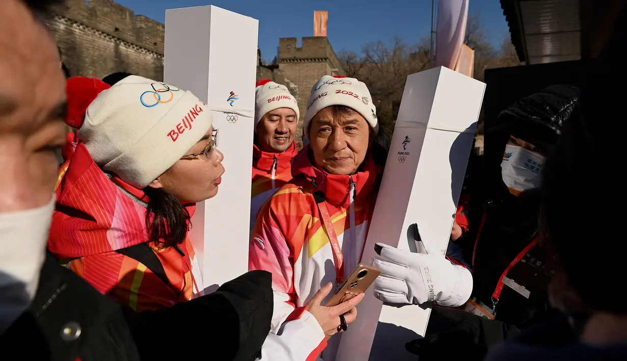 Aktor Jackie Chan dan seorang pembawa obor terlihat di Tembok Besar Badaling pada hari kedua estafet obor di Beijing pada 3 Februari 2022, sehari sebelum dimulainya Olimpiade Musim Dingin Beijing 2022. (AFP/Noel Celis)