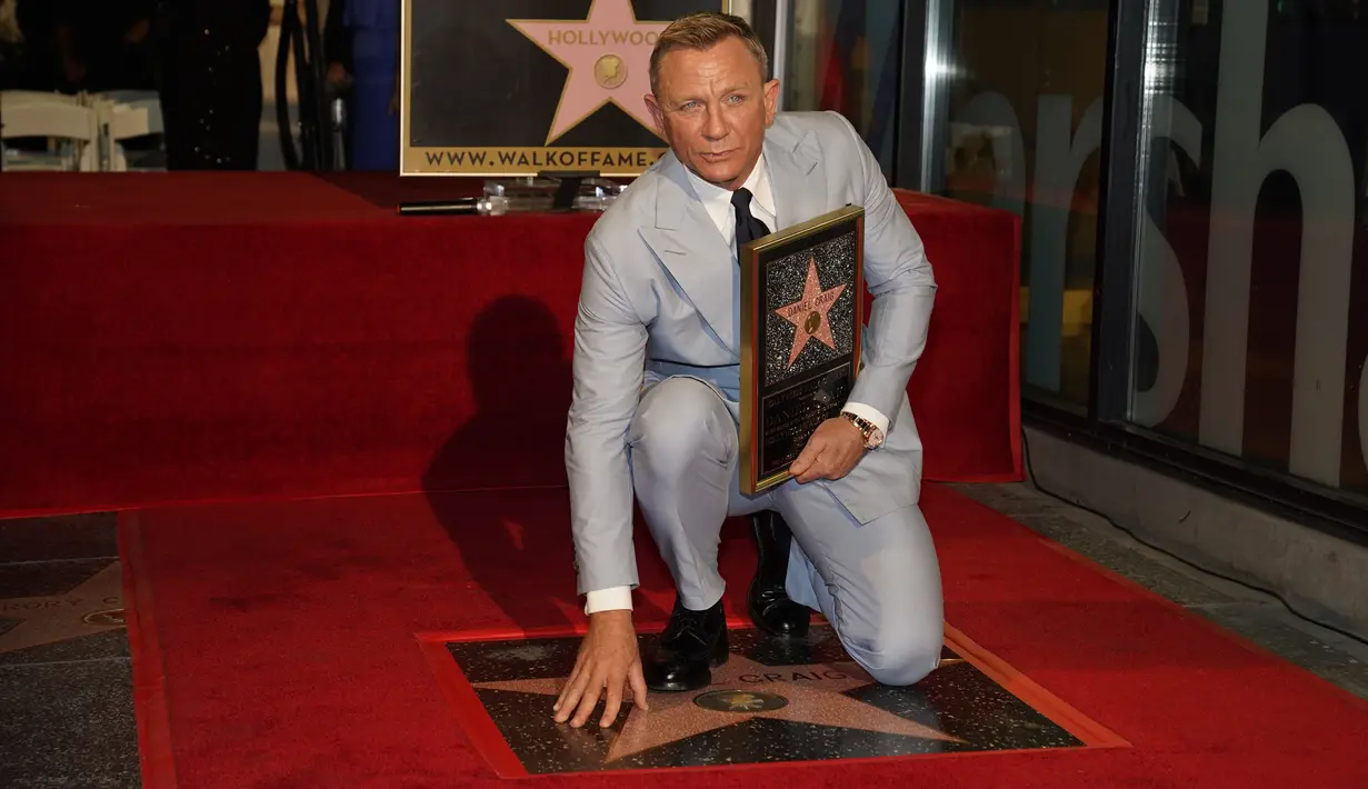 Daniel Craig berpose di atas bintang barunya di Hollywood Walk of Fame pada upacara penghargaan di Los Angeles, Rabu (6/10/2021). Nama Daniel Craig di Hollywood Walk of Fame diletakkan di samping aktor Roger Moore, pemeran James Bond terdahulu. (AP Photo/Chris Pizzello)