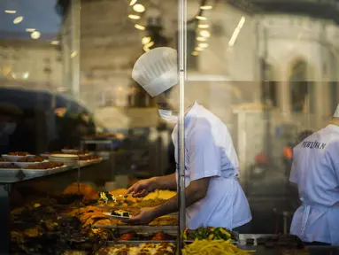 Juru masak menyajikan makanan untuk pelanggan di 'lokantasi' atau restoran populer di Istanbul, Turki, Senin (3/1/2022). Inflasi tahunan Turki naik dengan laju tercepat dalam 19 tahun, melonjak menjadi 36,08% pada Desember lalu, menurut data resmi pada Senin. (AP Photo/Francisco Seco)