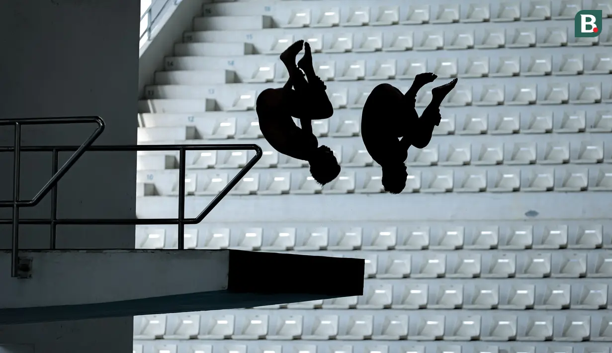 Siluet pasangan atlet loncat indah, Andriyan (kanan) dan Adityo Restu Putra saat beraksi pada nomor menara synchro putra Kejurnas Akuatik 2026 di Stadion Akuatik Gelora Bung Karno, Senayan, Jakarta, Selasa (05/05/2026). (Bola.com/Bagaskara Lazuardi)