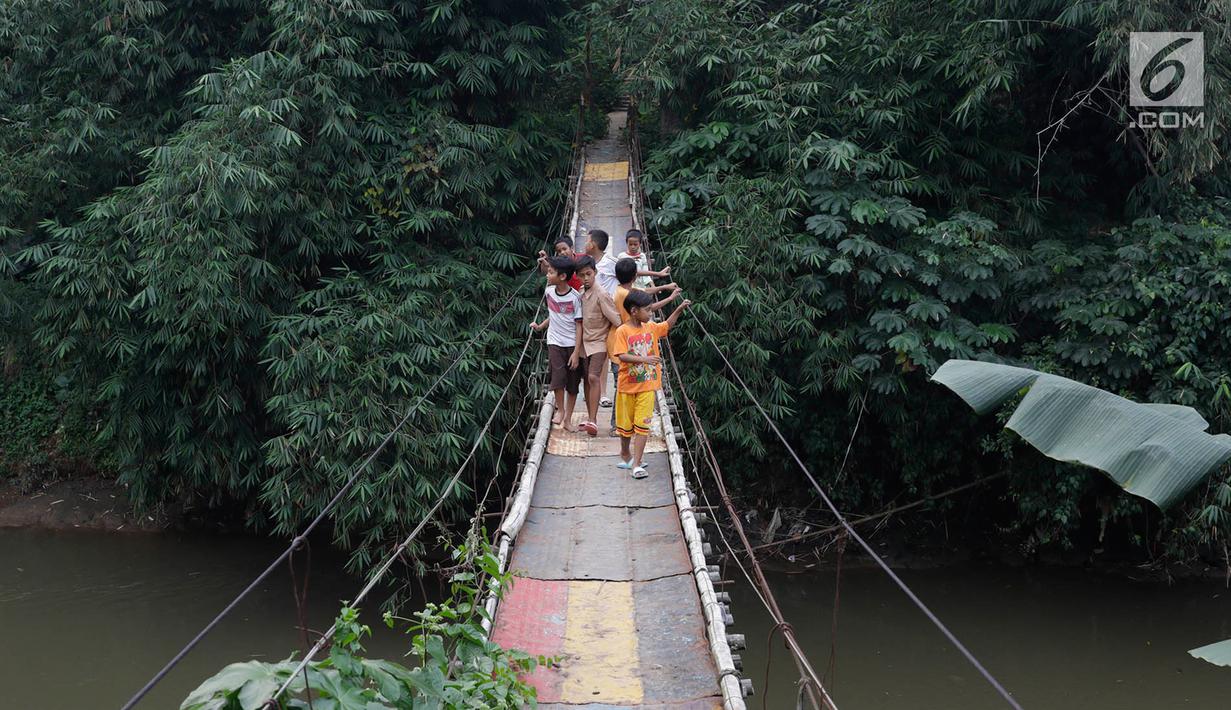 Warga melintasi jembatan penyeberangan buatan warga di kawasan Lenteng Agung, Jakarta, Rabu (24/5). Meskipun kondisinya memprihatinkan, warga setempat tetap menggunakan jembatan tersebut. (Liputan6.com/Immanuel Antonius)