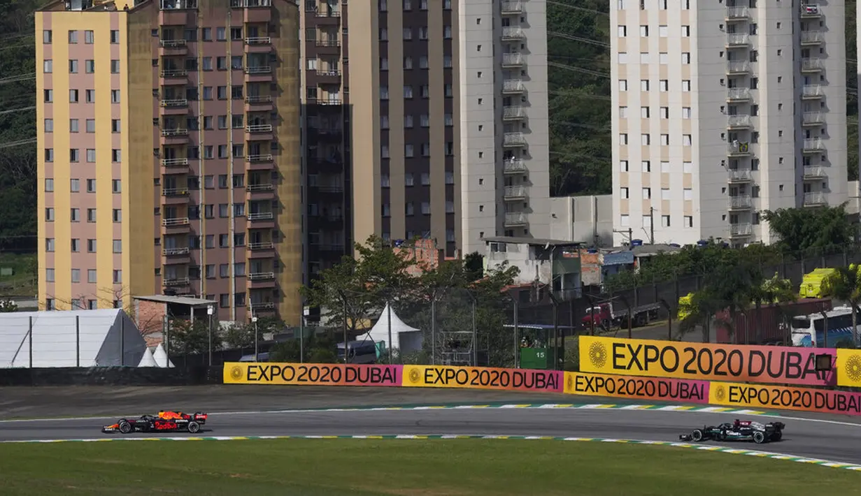 Pembalap Red Bull Max Verstappen (kiri) mengemudikan mobilnya diikuti pembalap Mercedes Lewis Hamilton pada Formula 1 Grand Prix di Sirkuit Interlagos, Sao Paulo, Brasil, 14 November 2021. Lewis Hamilton di urutan pertama, Max Verstappen kedua, dan Valtteri Bottas ketiga. (AP Photo/Andre Penner)