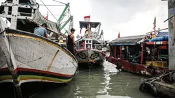 Nelayan beraktivitas di perahu saat bersandar di Pelabuhan Muara Angke, Jakarta, Senin (26/12/2022). Akibat angin  barat dan gelombang tinggi menyebabkan nelayan tradisional di Muara Angke libur melaut. (Liputan6.com/Faizal Fanani)