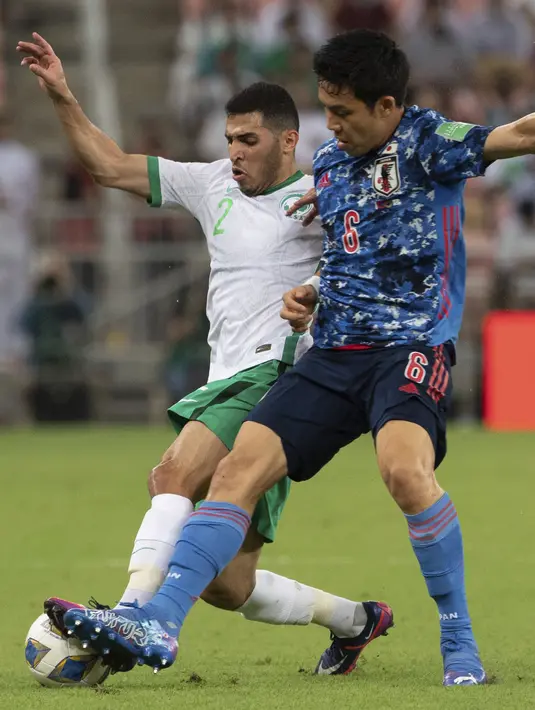 Gelandang Jepang, Wataru Endo berebut bola dengan pemain Arab Saudi, Sultan Al-Ghannam pada kualifikasi grup B zona Asia Piala Dunia Qatar 2022 di Stadion King Abdullah Sports City, Jeddah, Arab Saudi, Kamis (7/10/2021). Arab Saudi menang tipis atas Jepang 1-0. (AP Photo)