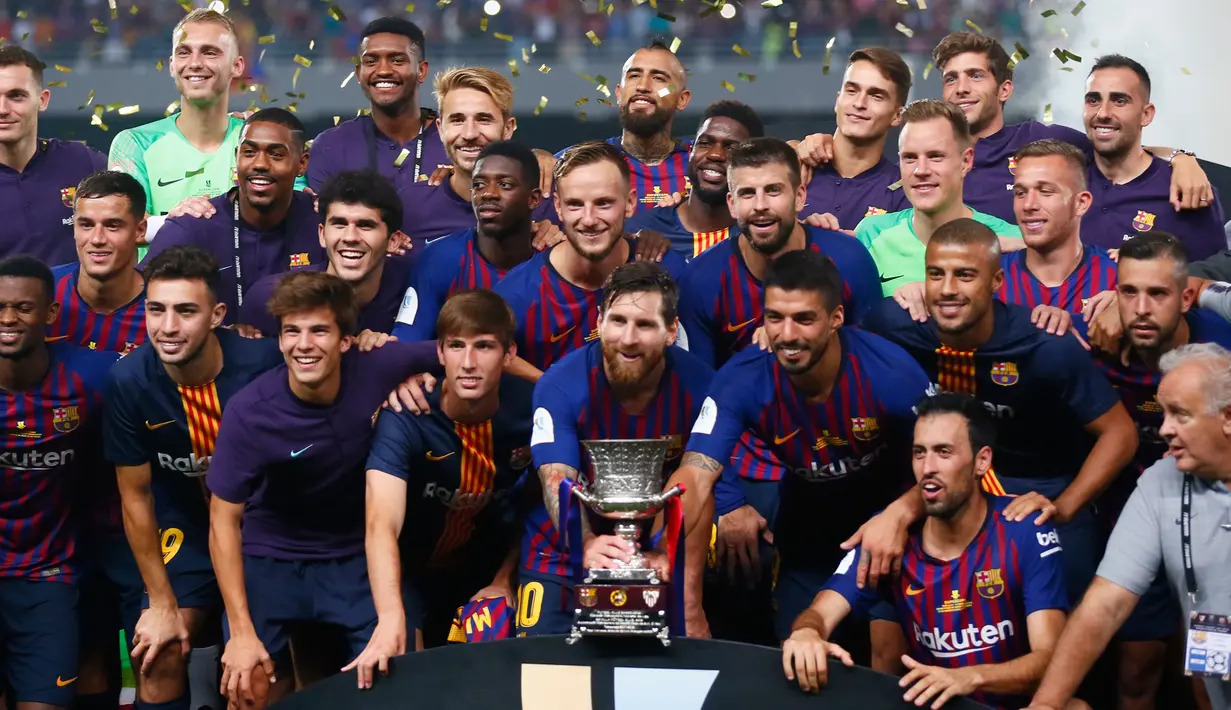 Pemain Barcelona berpose bersama trofi setelah berhasil mengalahkan Sevilla dalam pertandingan Piala Super Spanyol di Tangier, Maroko, (13/8). Barcelona berhasil mengalahkan Sevilla dengan skor 2-1. (AP Photo/Mosa'ab Elshamy)