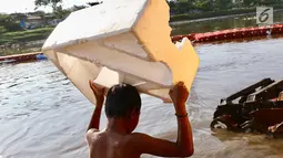 Seorang anak membawa styrofoam untuk berenang di Kanal Banjir Barat, Jakarta, Jumat (23/3). Anak-anak nekat berenang di lokasi ini meski berbahaya bagi kesehatan dan keselamatan. (Liputan6.com/Immanuel Antonius)