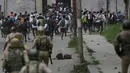 Polisi India mengejar pelajar yang melakukan aksi pelemparan batu di Srinagar, Kashmir, Rabu (17/5). Beberapa bulan belakangan ini keadaan di Kashmir terus diwarnai oleh bentrok antara pelajar dengan polisi. (AP Photo / Mukhtar Khan)