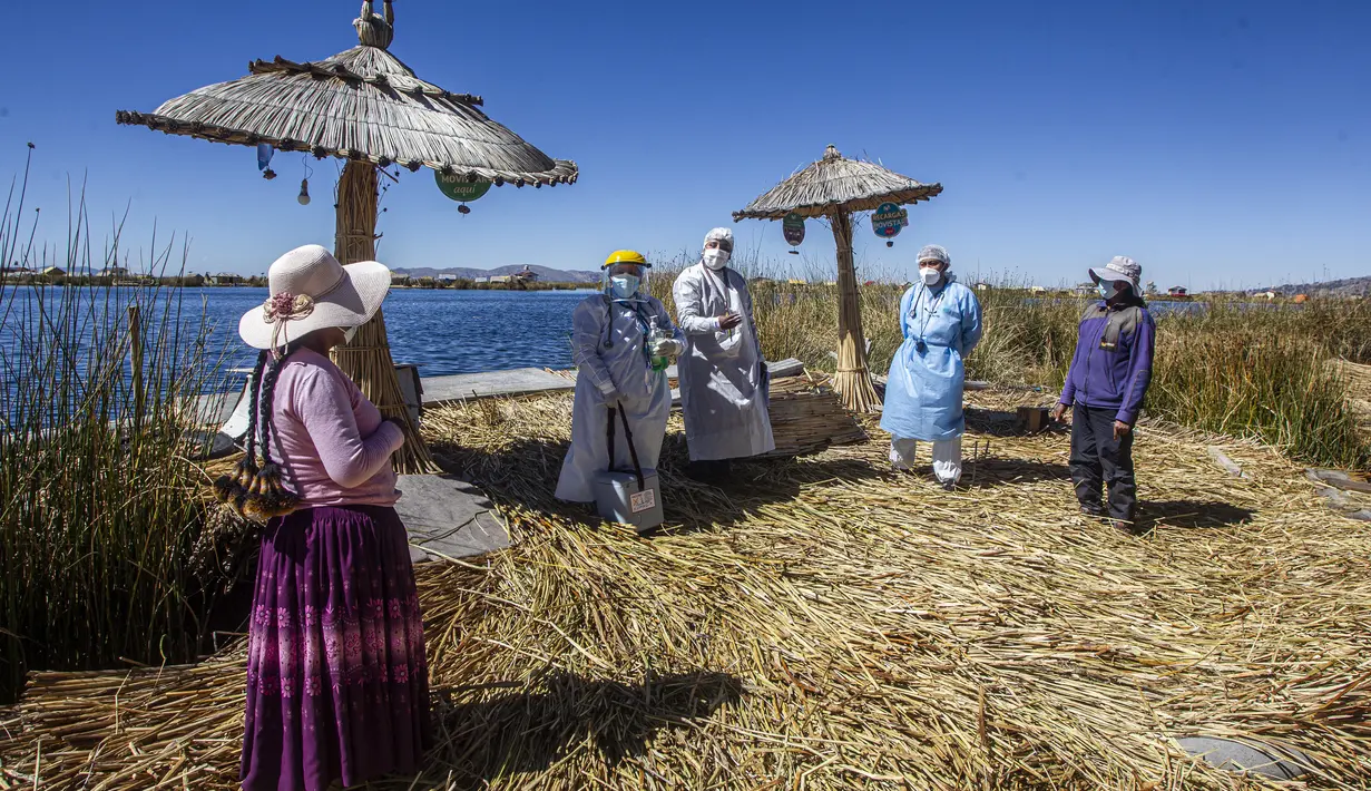 Petugas kesehatan tiba di pulau Uros untuk menyuntik warga dengan vaksin COVID-19 Sinopharm, di danau Titicaca di Puno, Peru, pada 7 Juli 2021. Peru memulai vaksinasi COVID-19 untuk ratusan penduduk asli yang tinggal di pulau terapung Uros, di Danau Titicaca. (Carlos MAMANI / AFP)