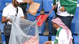 Suporter Arab Saudi mengumpulkan sampah di tribun seusai laga melawan Uruguay pada pertandingan kedua Grup A Piala Dunia 2018 di Rostov Arena, Rabu (20/6). Kalah 0-1, Arab Saudi menjadi tim kedua yang tersingkir setelah Maroko. (AFP/JOE KLAMAR)