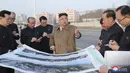 Pemimpin Korea Utara Kim Jong-un memberikan arahan kepada stafnya saat mengunjungi lokasi konstruksi pembangunan gedung apartemen di tepi Sungai Pothong, Korea Utara, Kamis (1//4/2021)..( STR/KCNA VIA KNS/AFP)