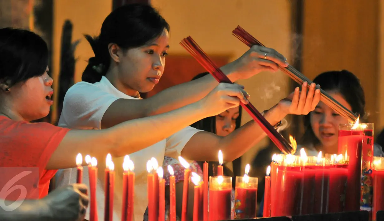 Umat Tionghoa membakar dupa saat melaksanakan ibadah malam Imlek di Vihara Dharma Bhakti, Jakarta, (7/2). Vihara Dharma Bakti pernah terbakar pada 2 Maret 2015 lalu akibat konsleting listrik. (Liputan6.com/Yoppy Renato)