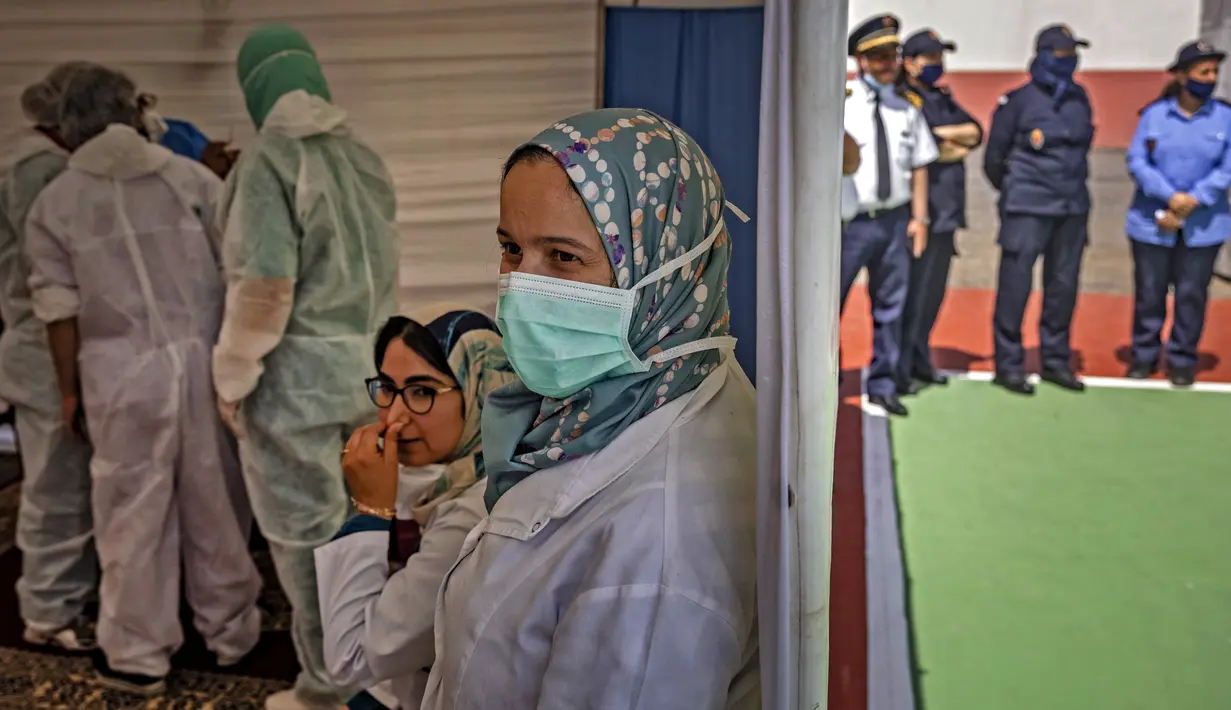 Petugas kesehatan menunggu narapidana yang telah dipanggil untuk menerima vaksin Covid-19 AstraZeneca di penjara El-Arjate dekat ibu kota Rabat pada 26 Mei 2021. Sekitar 300 narapidana di penjara tersebut diberi vaksinasi COVID-19 sebagai upaya mengekang penyebaran corona di Maroko (FADEL SENNA/AFP)