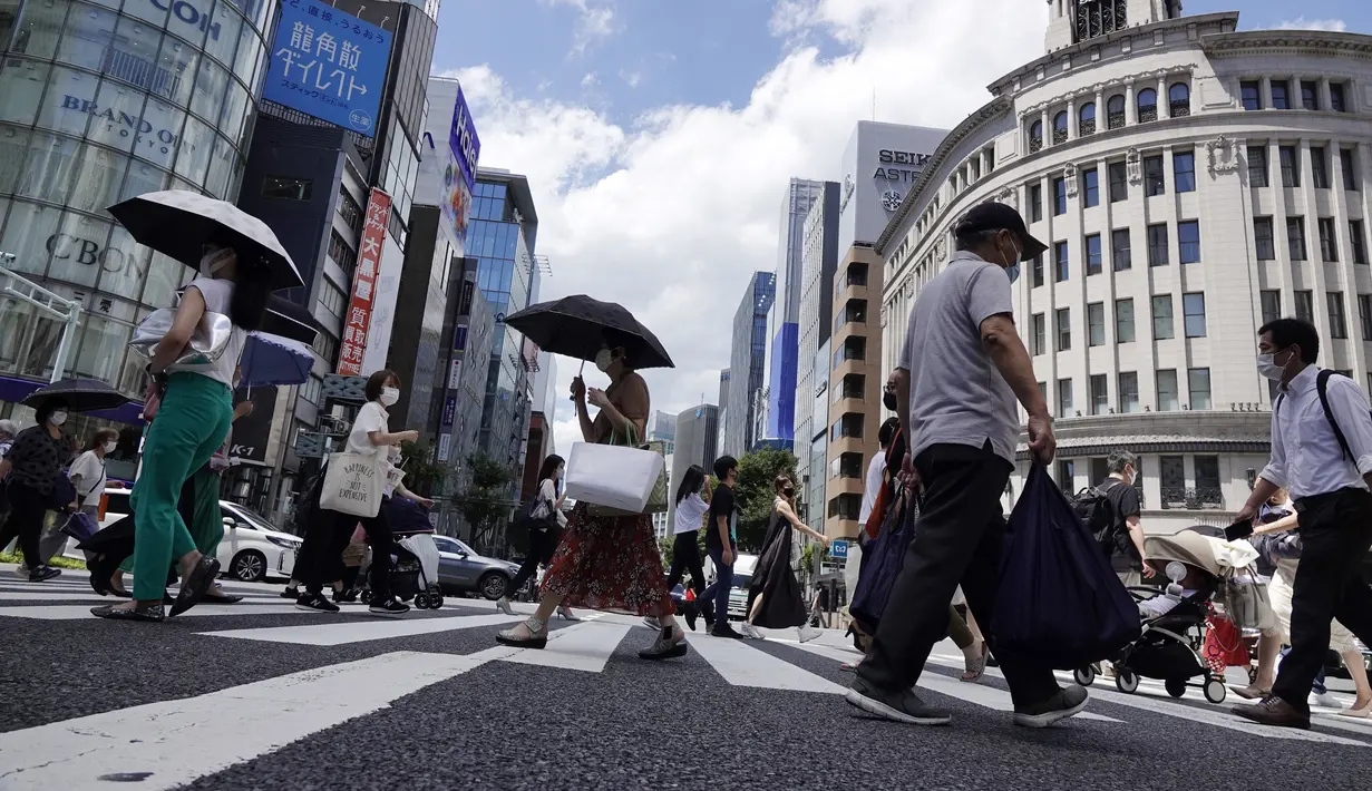 Orang-orang yang memakai masker untuk melindungi dari penyebaran virus corona berjalan di bawah terik matahari di distrik Perbelanjaan Ginza di Tokyo, Selasa (10/8/2021). (AP Photo/Eugene Hoshiko)