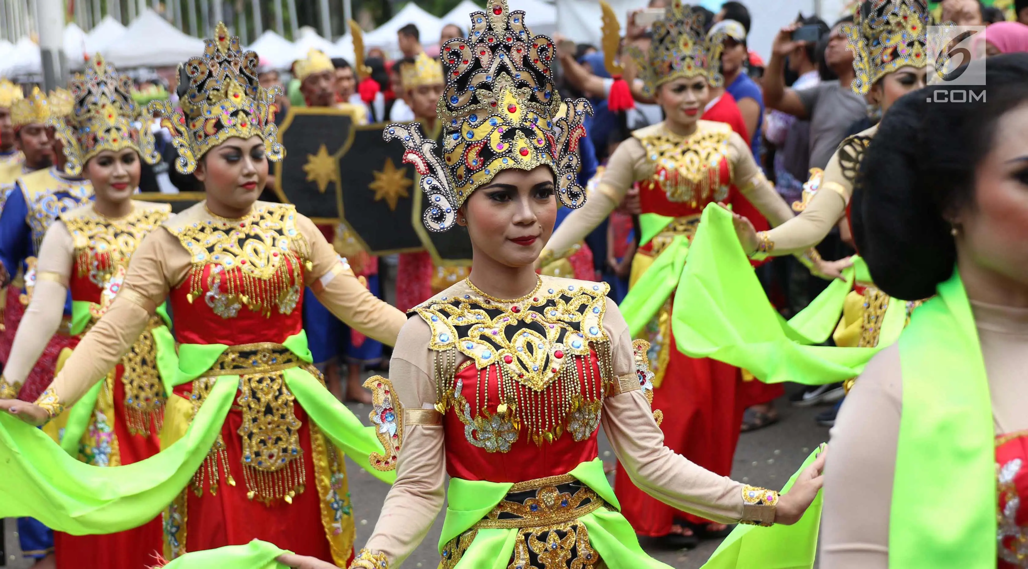 Sejumlah wanita menampilkan tarian daerah saat melakukan karnaval di jalan Pintu 1 Senayan, Jakarta, Minggu (24/9). Karnaval tersebut dilakukan dalam rangka HUT Gelora Bungkarno yang ke-55. (Liputan6.com/Angga Yuniar)