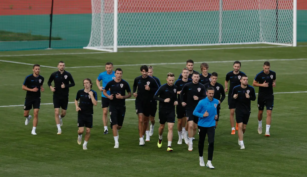 Para pemain timnas Kroasia melakukan pemanasan selama mengikuti sesi pelatihan tim di Moskow, Rusia, (13/7). Kroasia akan bertanding melawan timnas Prancis pada Final Piala Dunia 2018. (AFP Photo/Adrian Dennis)